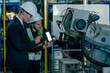 © Hip.hub - Engineers inspect robotic machinery in a manufacturing facility during a quality control assessment