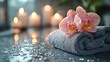 © delvin std - Serene spa setting featuring a soft towel, delicate orchids, and glowing candles in a tranquil atmosphere
