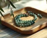 A handcrafted jade necklace with unique bead shapes, resting on a smooth bamboo tray for a minimalist aesthetic