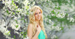 © rohappy - Beautiful blonde young woman in spring blooming garden on a sunny day against flowers trees