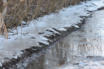 Poster - The texture of cracked ice on the river in the early spring after low tide