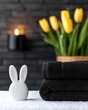 © VANATSANUN - A cozy spa setting with towels, a rabbit figurine, and vibrant tulips in a serene atmosphere.