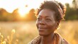 © iuricazac - A smiling woman standing in a field of high grass, looking towards the sunset, with yellow flowers in her hair.