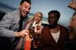 © liderina - Group of Multi-Ethnicity people having fun outdoor in the night. Celebrate.