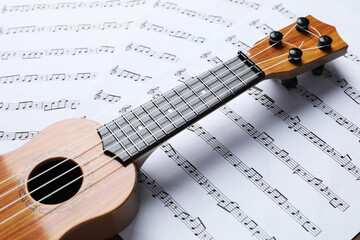 Wall Mural - One ukulele on music sheets, closeup view