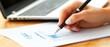 © felix_brönnimann - Business Professional Analyzing Financial Data and Charts on Paper with Laptop in Background for Office and Work Environment
