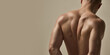 © Lustre Art Group  - Close-up of male model's sculpted back with natural light accentuating muscular, healthy structure against warm beige studio background. Concept of beauty, fashion, style, masculinity.