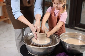 Wall Mural - Hobby and craft. Daughter with her mother making pottery indoors, closeup