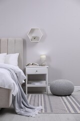 Wall Mural - Stylish bedroom interior with knitted pouf and furniture