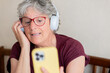 © ADDICTIVE STOCK - Senior woman enjoying a video call with headphones on