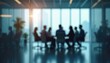© miss irine - Blurred silhouette of business people in conference room. Team sitting at table discussing project strategy. Modern office workspace interior. Brainstorming teamwork meeting, collaboration in