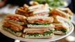 © AlfaSmart - Delicious smoked salmon sandwiches with cream cheese and arugula on a platter