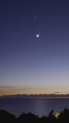 Wall Mural - crescent moon above sunset sky and seascape, vertical view