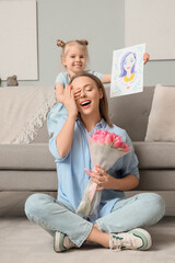 Wall Mural - Little girl greeting her mother with drawing and tulips at home. International Women's Day