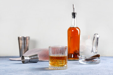 Wall Mural - Glass of cold rum on table against blurred background. Closeup