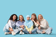 © Pixel-Shot - Group of beautiful women sitting on blue background. Women's History Month