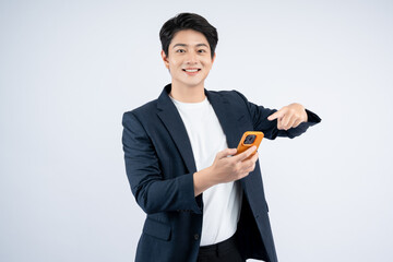 Wall Mural - Portrait of young Asian business man using phone and posing on white background