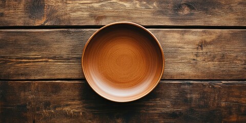 Fototapete - Vacant circular dish in warm brown tones placed centrally on textured wooden surface captured from bird's eye view showcasing rustic ambiance
