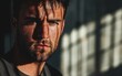 © Sergey Fedchenko - Moody close-up of a man with rugged stubble deep contrast and dramatic shadows blurred industrial backdrop