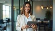 © Png Stock25 - Portrait of young Hispanic professional business woman standing in office. Happy female company executive, smiling businesswoman entrepreneur corporate leader manager looking at camera using tablet