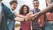 © Lomb - Collective Commitment: Diverse multigenerational team stacking hands for a shared goal and trust.