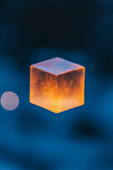 Poster - Close-up macro shot of a single luminescent cube partially blurred by a foreground layer of