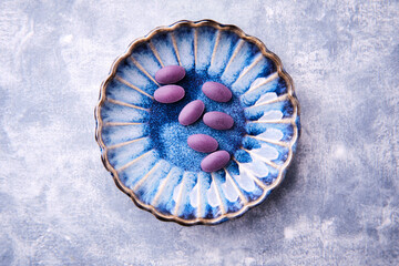 Wall Mural - Lutein tablets. Dietary supplement on wooden background. Soft focus. Top view. Close up. Copy space