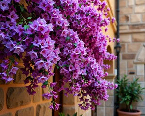 Wall Mural - Vibrant purple flowers cascade beautifully against a stone wall, adding color and charm to the serene outdoor setting.