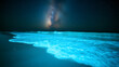 © Photo by mQ - A glowing bioluminescent beach at night, where every wave illuminates in electric blue as it crashes onto the shore. The Milky Way shines above, completing this otherworldly, breathtaking scene.