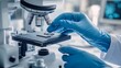 © Karo - A close-up of hands in blue gloves holding and examining a microchip, with a microscopic background.