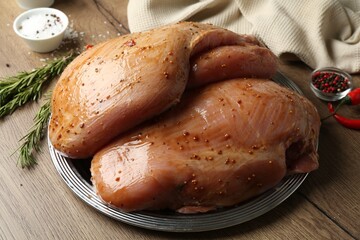 Wall Mural - Raw marinated turkey breasts on wooden table, closeup