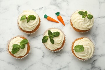 Wall Mural - Delicious carrot cupcakes with mint on white marble table, flat lay