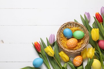 Wall Mural - Easter eggs and beautiful tulips on white wooden background, flat lay. Space for text