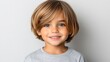© Oleksandr - Smiling young boy showing healthy looking directly at the camera with a classic bowl cut. Isolated on a light gray background.