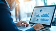 © Tondone - Businessman analyzing data on laptop in modern office environment, focused on charts and graphs, showcasing productivity and technology