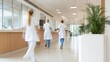 © OleksandrZastrozhnov - Three nurses walk down a hallway in a hospital. Blurred in motion hospital corridor with running doctors in uniform..