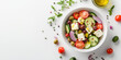 © Olha Lomova - A refreshing Greek salad in a white bowl, with crisp cucumber slices, cherry tomatoes, red onion, Kalamata olives, and feta cheese cubes, drizzled with olive oil. The dish is placed on the right side