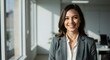 © TJ_Designs - beautiful smile woman wearing a business suit, standing in the office, sunshine, with a little bit of blurred background with copy space