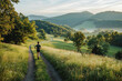 © Vadym Hunko - Man running on a scenic dirt trail through lush green hills in the morning, surrounded by nature and misty mountains.