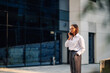 © Zamrznuti tonovi - Businesswoman talking on phone outside office building