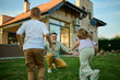 © Zamrznuti tonovi - Grandchildren running to hug grandfather in backyard