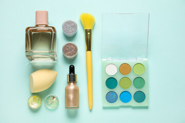 Wall Mural - Composition with bottle of perfume, jars of glitter, makeup products and accessories on turquoise background