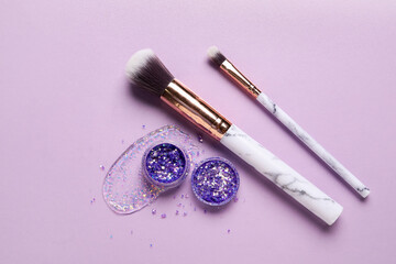 Wall Mural - Makeup brushes and jars of glitter with stroke on lilac background