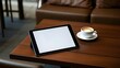 © Mochamad - Mockup image of tablet with plain white screen and coffee cup on wooden table in cafe,blurry background,coffe,tablet