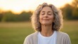 © Imagine Stuff - Serene elderly woman enjoying nature at sunset in a peaceful field