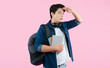 © STOCK88PHOTOGRAPHER - Portrait of Asian male student wearing backpack and headphones, holding book , surprised expression looking forward on pink background