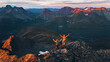 © EVERST - Couple hiking in Norway man and woman friends raised hands enjoying aerial sunset mountains view, active vacations healthy lifestyle tour outdoor family adventure mountaineering trip in Lyngen Alps