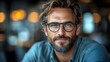 © Pamornpol - Portrait of a Confident Man: A striking portrait of a handsome man, sporting glasses and a well-groomed beard, exuding an air of sophistication and self-assurance.