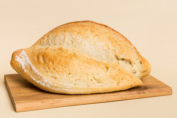 Wall Mural - Freshly baked bread on cutting board against white wooden background. perspective view bread with copy space