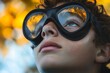 © c80 - Young boy looks up in curiosity while wearing oversized goggles in a colorful outdoor environment during autumn